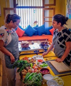 Local chef explaining ingredients during an Ella cooking class, sharing traditional recipes and authentic Sri Lankan cooking techniques